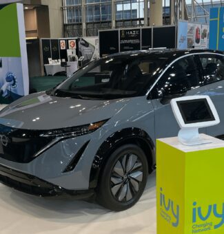 AutoShow event from 2023 with electric vehicle car and charger display.